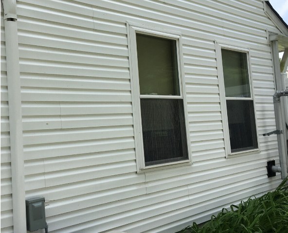 The same house after a soft wash — siding bright, white, and clean