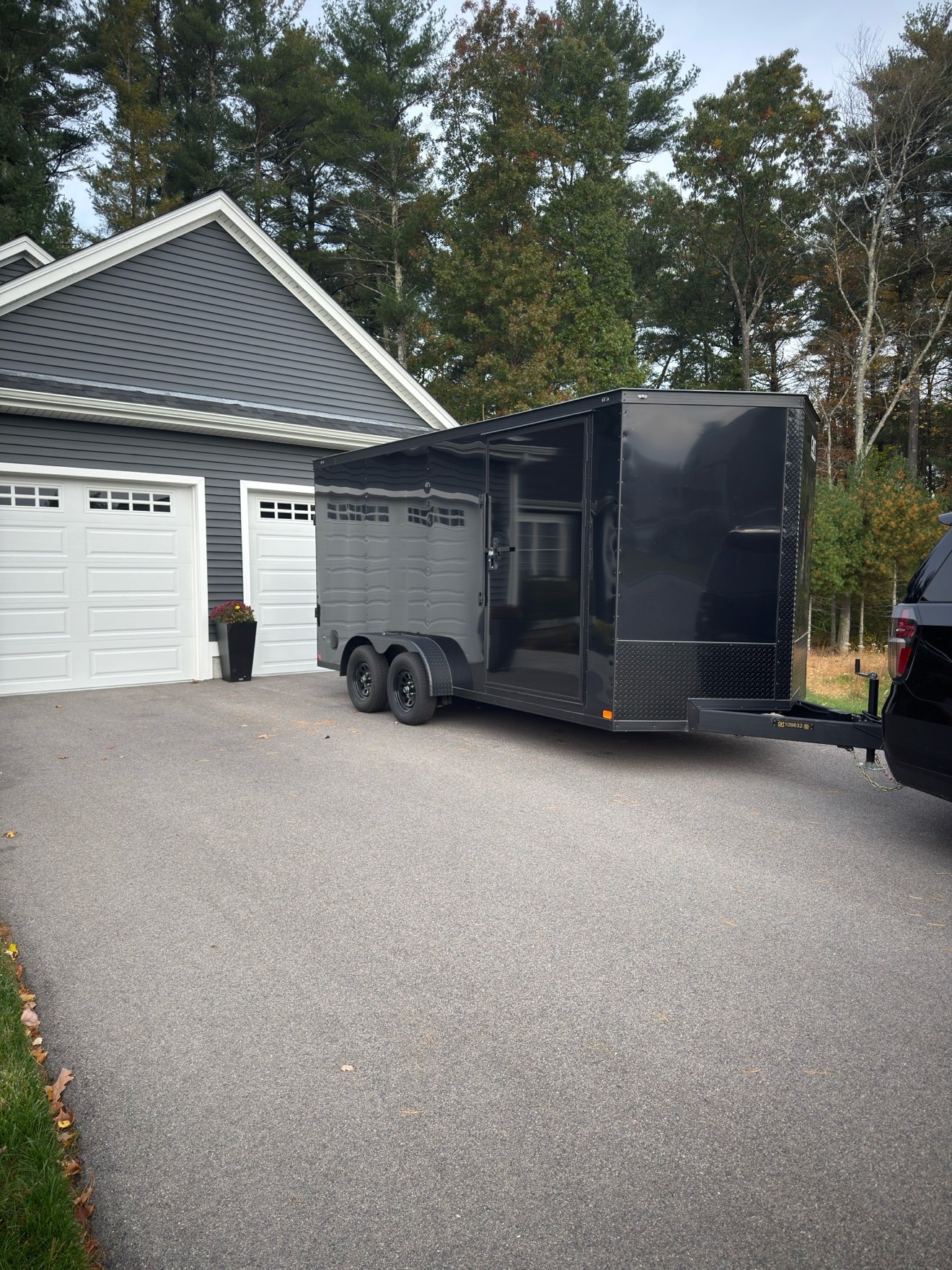 Front three-quarter view of Blackrock's black enclosed dual-axle trailer, hitched up and ready to roll